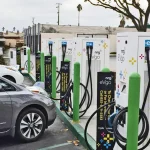 Two cars parked at an electric car charging station.